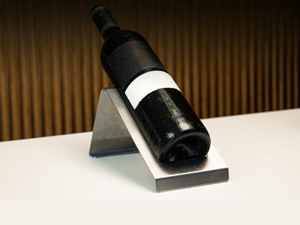 Botella de vino posada en expositor.